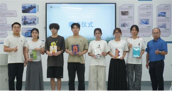 学生处处长助理黄锦华、信息工程学院党总支书记喻瑞文为受助学生代表赠书.png