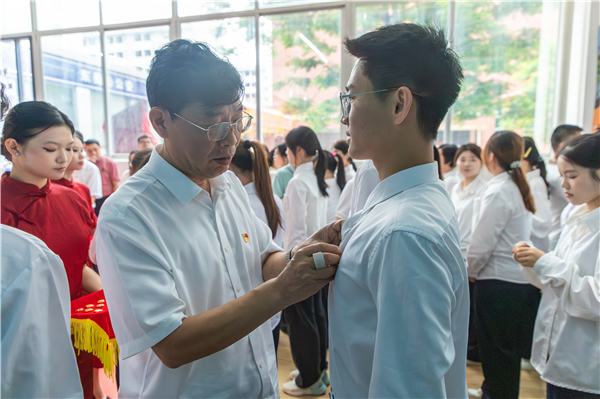 学校领导与各学院党总支书记共同为新发展的师生党员佩戴党徽1.png
